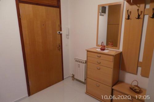 a bathroom with a wooden dresser and a mirror at Walk Apartment in Vukovar