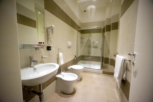 une salle de bain avec un lavabo, des toilettes et une douche dans l'établissement Sant'Agostino Affittacamere, à Reggio de Calabre
