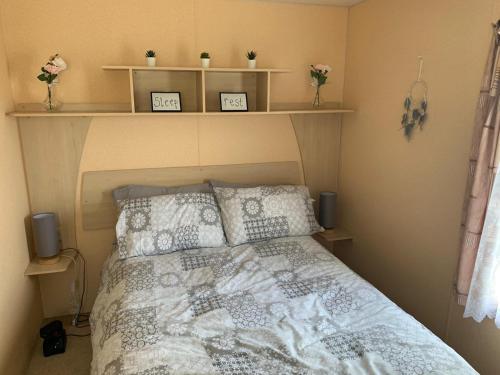 a bedroom with a bed with two shelves above it at Sunnymede Ingoldmells Fantasy Islands Static Caravan Park in Skegness
