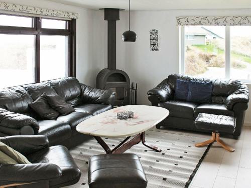 a living room with leather furniture and a fireplace at 6 person holiday home in R m in Bolilmark