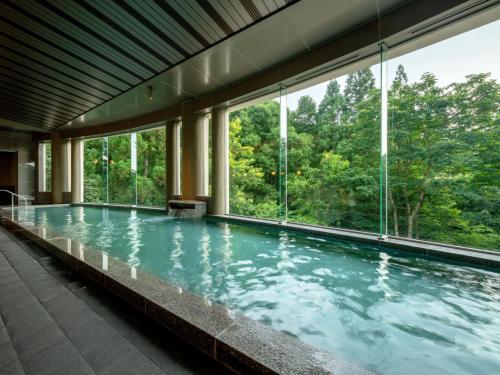 蔵王温泉にある蔵王四季のホテルの大きな窓のあるスイミングプール