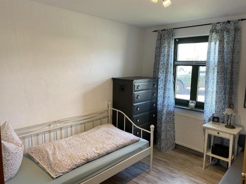 a bedroom with a bed and a dresser and a window at Quaint Apartment in Dargun Mecklenburg with Swimming Pool in Barlin
