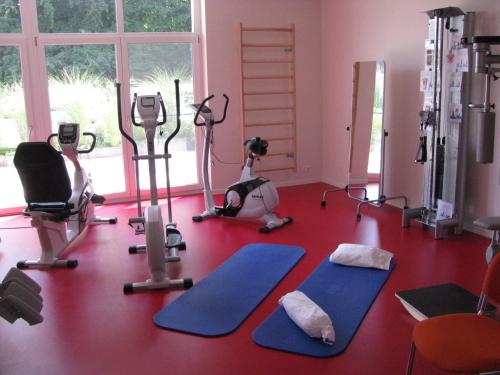 a gym with several treadmills and exercise bikes at Hotel Restaurant Sokrates in Güttingen
