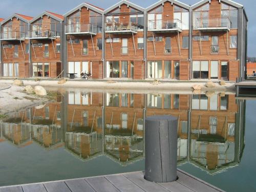 ein Gebäude mit Reflexion in einem Wasserkörper in der Unterkunft 4 person holiday home in Bogense in Bogense