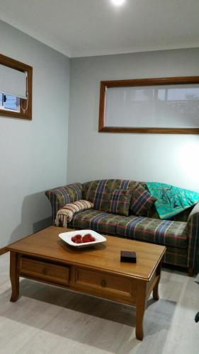 een woonkamer met een bank en een salontafel bij Never Inn in Kiama