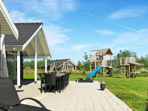 a patio with a playground with a slide at 14 person holiday home in Idestrup in Marielyst