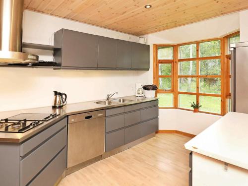 a kitchen with stainless steel appliances and wooden ceilings at 6 person holiday home in L s in Læsø