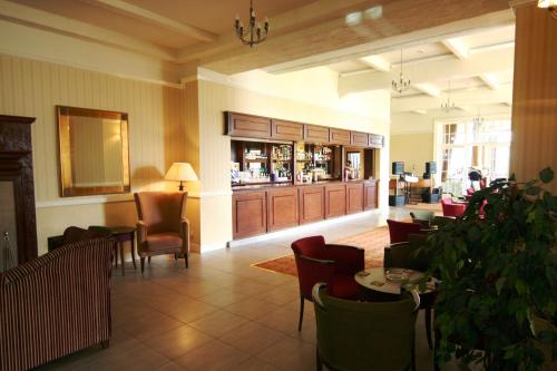 a lobby with a restaurant with chairs and a bar at Cumbria Grand Hotel in Grange Over Sands