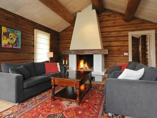 a living room with two couches and a fireplace at 12 person holiday home in F vang in Tromsnes