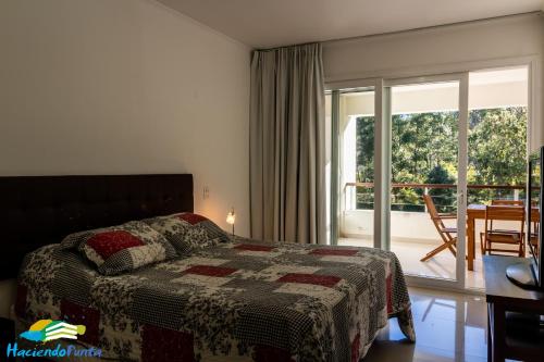 een slaapkamer met een bed en een balkon bij Green Park Propietarios in Punta del Este