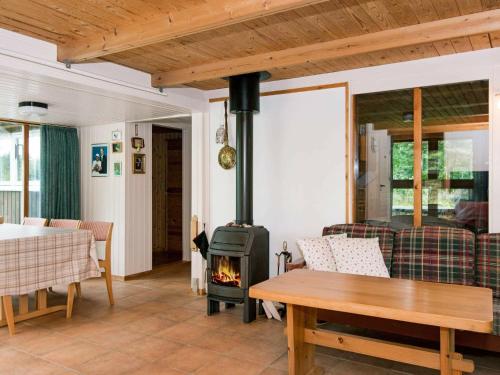 ein Wohnzimmer mit einem Holzofen und einem Tisch in der Unterkunft 7 person holiday home in Kolind in Kolind