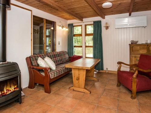 7 person holiday home in Kolind في Kolind: غرفة معيشة مع أريكة ومدفأة