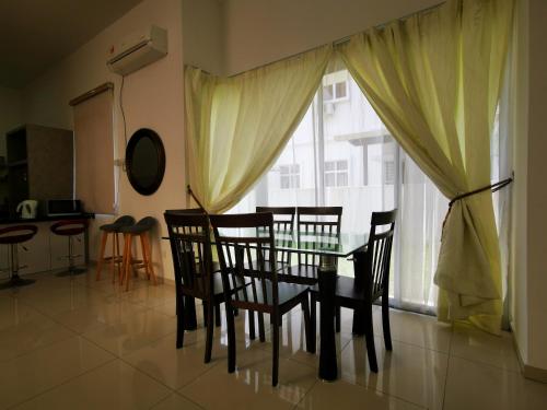comedor con mesa, sillas y ventana en Venn Homestay, Balik Pulau, en Balik Pulau