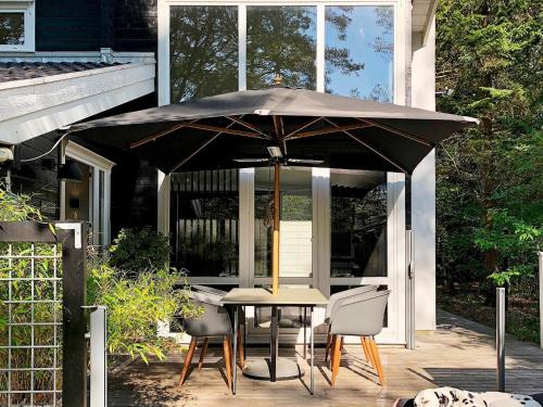 a table and chairs under an umbrella on a patio at Luxury Spa Retreat in Thorsager - By Traum Ferienwohnungen in Rønde