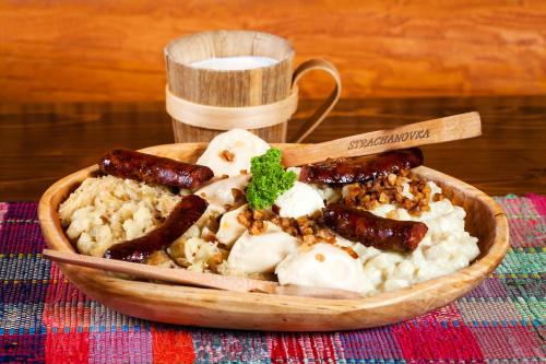 a bowl of food with sausage and rice on a table at Hotel Strachanovka - Jánska Koliba in Liptovský Ján