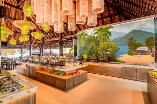 Chaweng Garden Beach Resort - SHA Plus في شاطئ تشاوينغ: مطعم الثريا كثيرة معلقة من السقف
