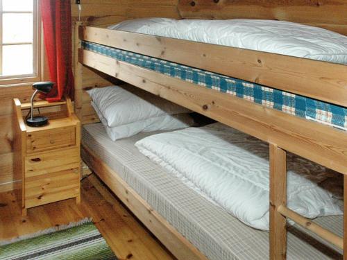 two bunk beds in a cabin with a night stand at Two-Bedroom Holiday home in Surna in Glerem