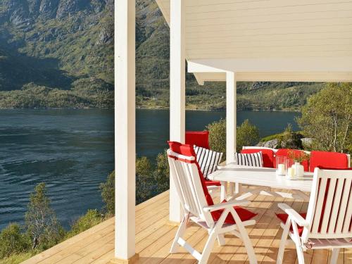 a white table and chairs on a porch with a view of the water at 8 person holiday home in Tengelfjord in Tengelfjorden