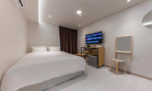 een hotelkamer met een bed en een televisie bij 1962 Business Hotel Chuncheon Branch in Chuncheon