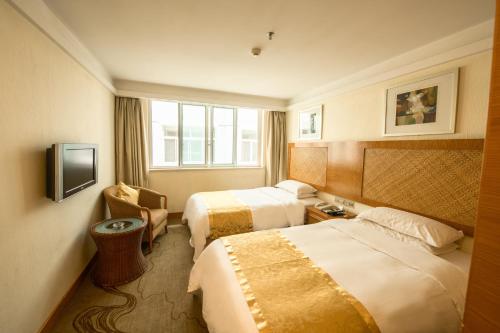 a hotel room with two beds and a television at Huangshan Leaf Spring Resort Hotel in Huangshan City
