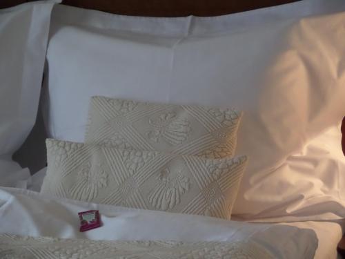 a white bed with white sheets and pillows at Astoria Bed & Breakfast in Swarzędz