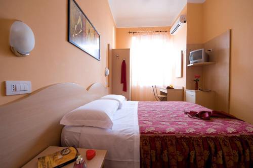 a bedroom with a bed with a red and white blanket at Hotel Sabatino Milan in Milan
