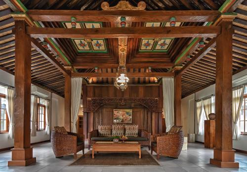 a living room with a wooden ceiling and a couch at Villa Berawa in Canggu