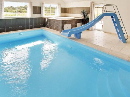 a large blue swimming pool with a slide in a house at 20 person holiday home in Vejby in Vejby