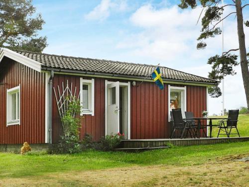 una casita roja con una bandera. en 4 person holiday home in LYSEKIL, en Lysekil