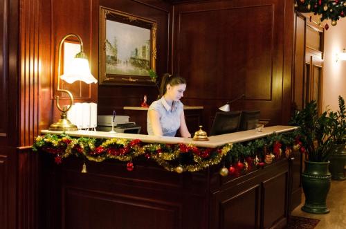 una mujer está sentada en un escritorio con un micrófono en Hotel Dorottya, en Kaposvár