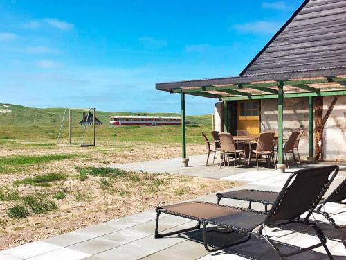 a patio with chairs and a table and a playground at 7 person holiday home in Harbo re in Harboør