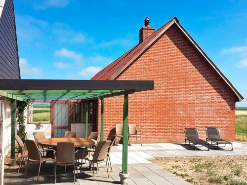 a patio with a table and chairs and a brick building at 7 person holiday home in Harbo re in Harboør