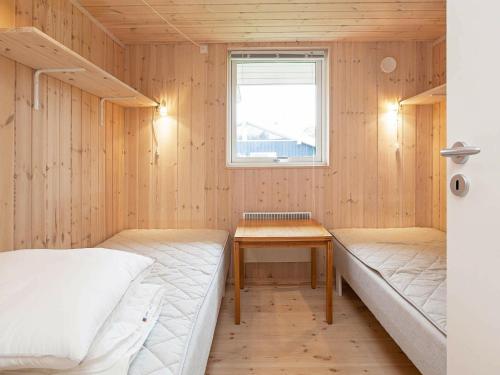 AsnæsにあるHoliday home Asnæs IIIのベッド2台とテーブルが備わる客室です。