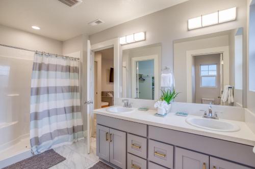 Un baño con dos lavabos y una ducha. en Oceans Treasure - Meredith Lodging, en Tillamook