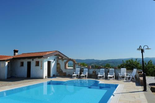 
a white swimming pool with a blue chair at Belica Bed and Breakfast in Dobrovo
