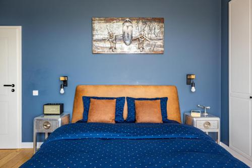 a blue bedroom with a bed with blue walls at The Aviator Apartment - Jacuzzi & Panoramic View in Cluj-Napoca