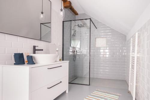 a white bathroom with a sink and a shower at Hygge Hut in Vama