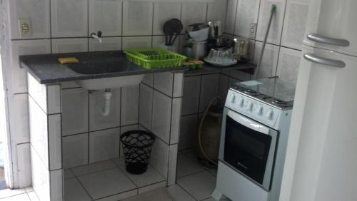 a small kitchen with a sink and a stove at Pousada Iguape Apartamentos - Unidade Ilha Comprida in Ilha Comprida