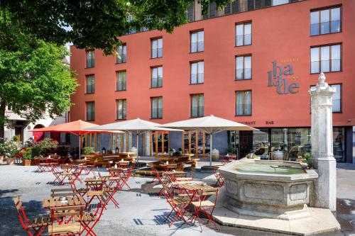 a large building with tables and chairs in front of it at Hotel Balade in Basel
