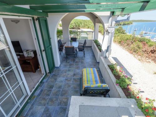 eine Terrasse mit einem Tisch, Stühlen und Meerblick in der Unterkunft Charming Holiday House in a quiet area large covered terrace with great sea view in Veli Rat