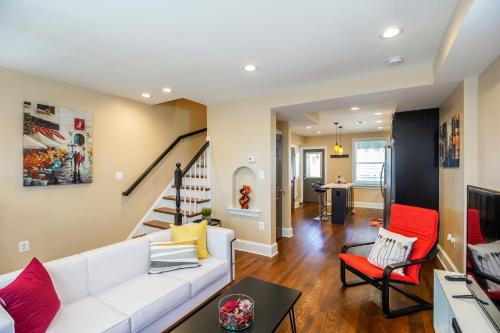 a living room with a white couch and red chairs at Luxurious DC Townhome ideal for Large Families plus Free Parking in Washington, D.C.