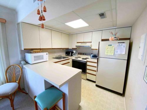 オーシャンシティにあるOcean Princess 207のキッチン(白い冷蔵庫、カウンター、椅子付)