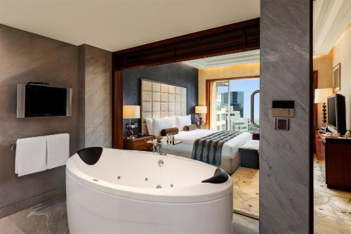 a hotel room with a tub and a bed at Crowne Plaza Today Gurugram by IHG in Gurgaon
