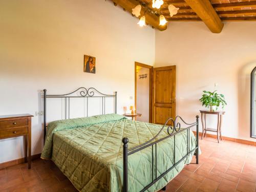 a bedroom with a bed with a green bedspread at Scenic Apartment Near Pian di Sco with Private Terrace in Pian di Scò