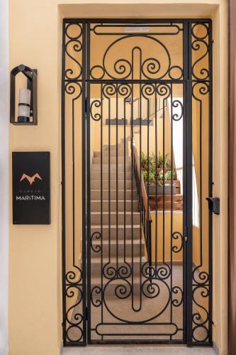 an iron gate with a staircase in a building at Camere Maritima in Chania Town