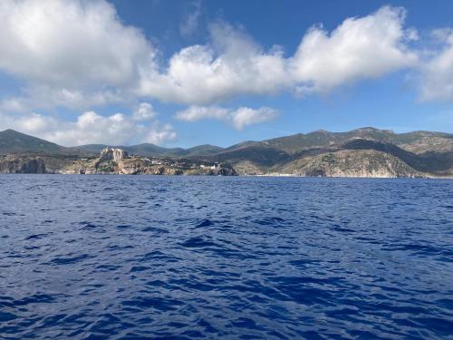 a large body of water with mountains in the background at Casa del porticciolo di Capraia in Capraia