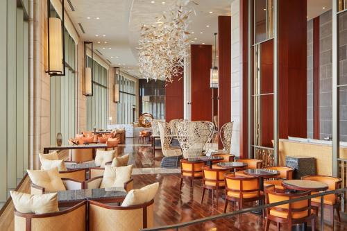 a lobby with chairs and tables and a chandelier at The Tsubaki Tower in Tumon