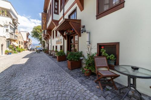 eine Straße mit einem Tisch und Stühlen außerhalb eines Gebäudes in der Unterkunft Armistis Hotel in Mudanya