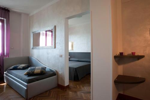 a room with a couch and a bed and a mirror at Hotel Astoria in Fermo