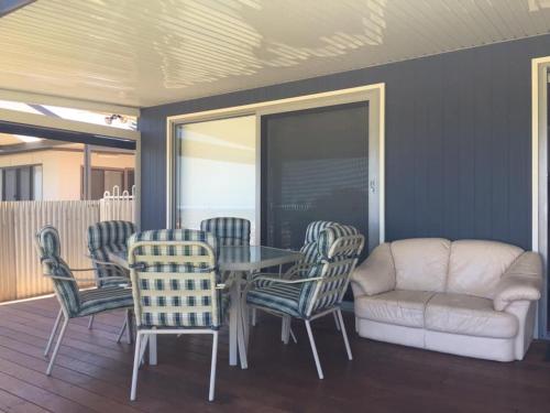 a dining room with a table and chairs and a couch at Family Tides in Wallaroo